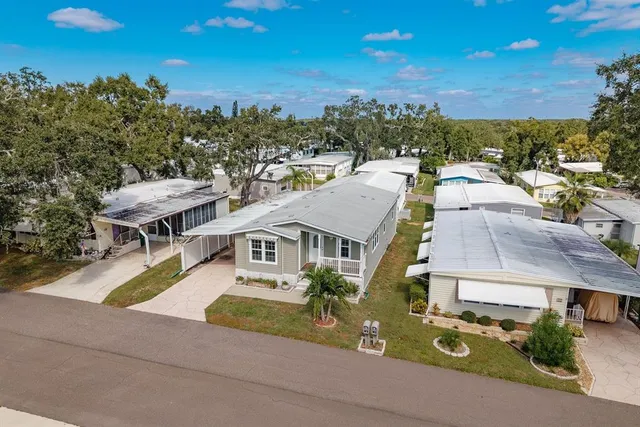 a view of a house with a yard and table and chairs under an umbrella