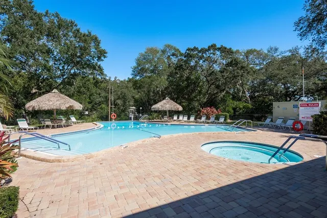 a view of a swimming pool with a patio and a yard