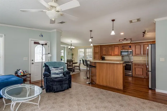 a living room with furniture kitchen view and a chandelier