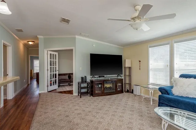 a kitchen with stainless steel appliances granite countertop a stove top oven a refrigerator a dining table and chairs with wooden floor