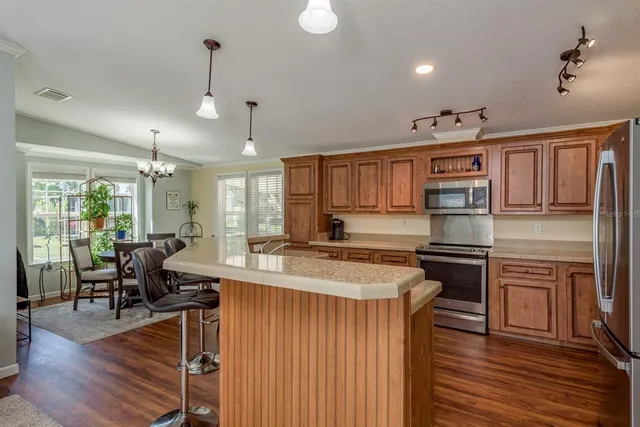 a kitchen with stainless steel appliances granite countertop a stove refrigerator and cabinets