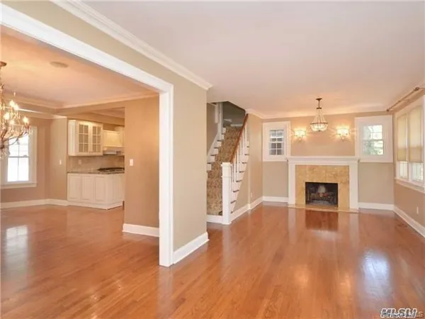 a view of a livingroom with wooden floor and a fireplace