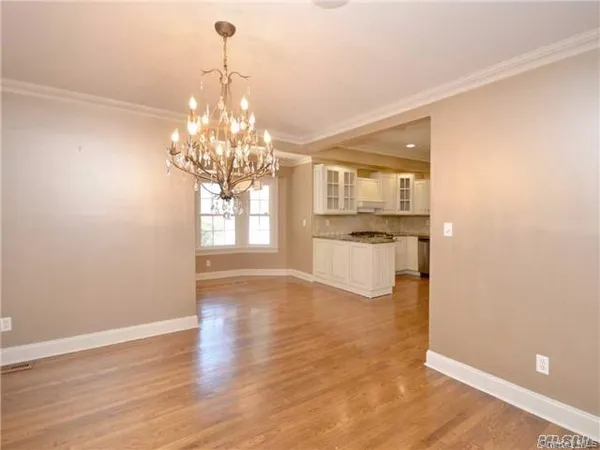 a view of a room with wooden floor and large windows