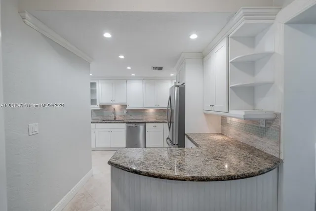 a kitchen with kitchen island a sink stove and refrigerator