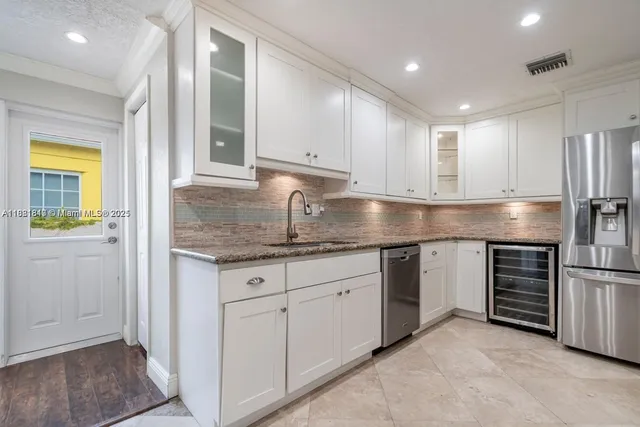 a kitchen with stainless steel appliances granite countertop a refrigerator and a sink
