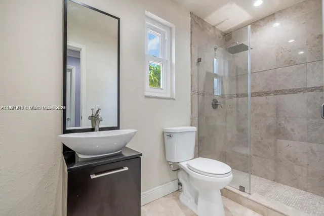 a bathroom with a sink a toilet and shower