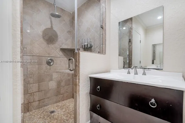 a bathroom with a granite countertop sink a mirror and shower