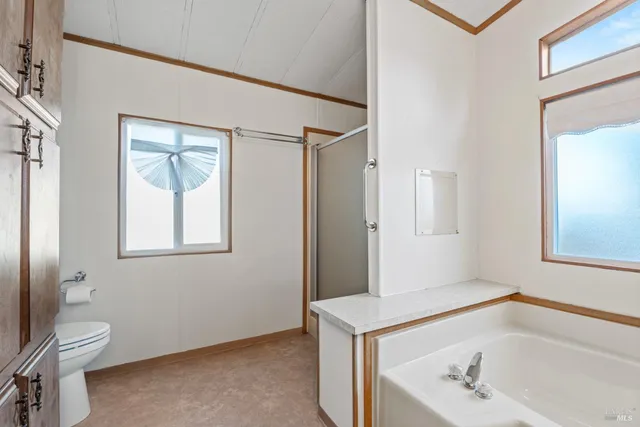 a bathroom with a tub a sink and a window