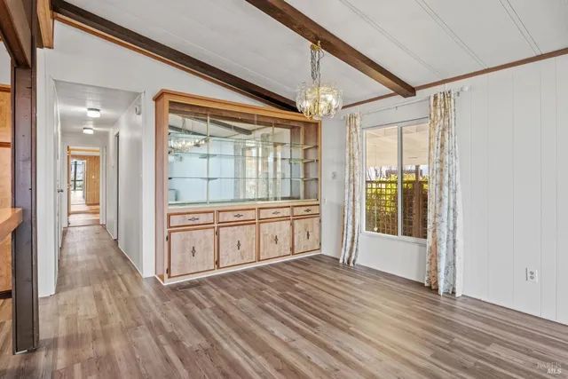 a view of a entrance and room with wooden floor