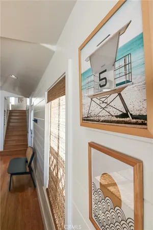 a view of a hallway with wooden floor and a large mirror