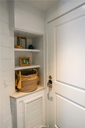 a room with a refrigerator and a wooden floor