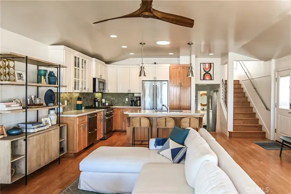 a living room with stainless steel appliances furniture and a kitchen view
