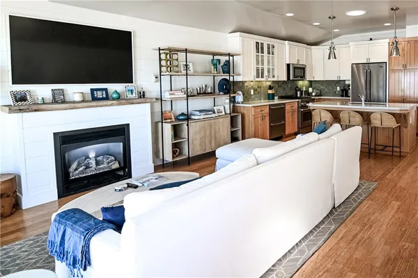 a living room with stainless steel appliances furniture and a flat screen tv