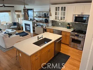 a kitchen with stainless steel appliances a stove a sink a microwave a refrigerator and cabinets