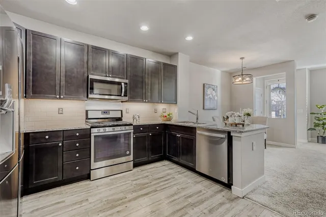 a kitchen with stainless steel appliances granite countertop a stove top oven sink and cabinets