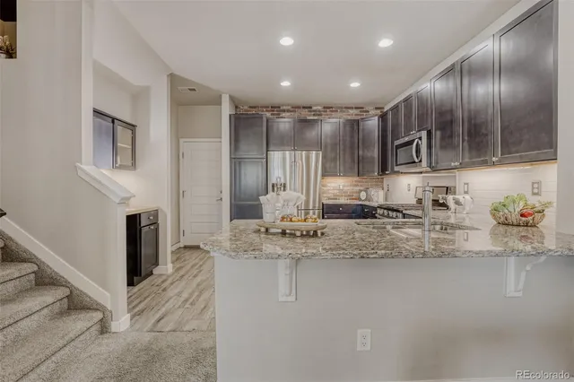 a large kitchen with kitchen island granite countertop a large counter top stainless steel appliances and cabinets