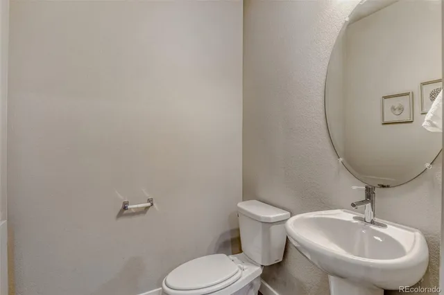 a bathroom with a sink mirror and toilet