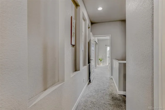 a view of a hallway with wooden floor and closet