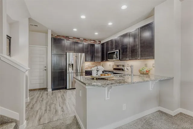 a kitchen with stainless steel appliances granite countertop a refrigerator and a sink