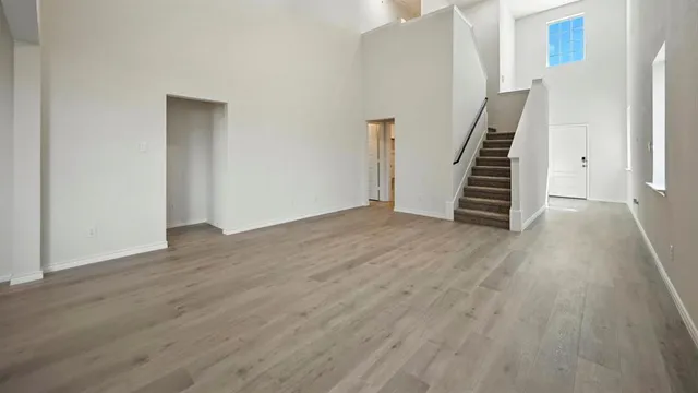 an empty room with wooden floor and stairs
