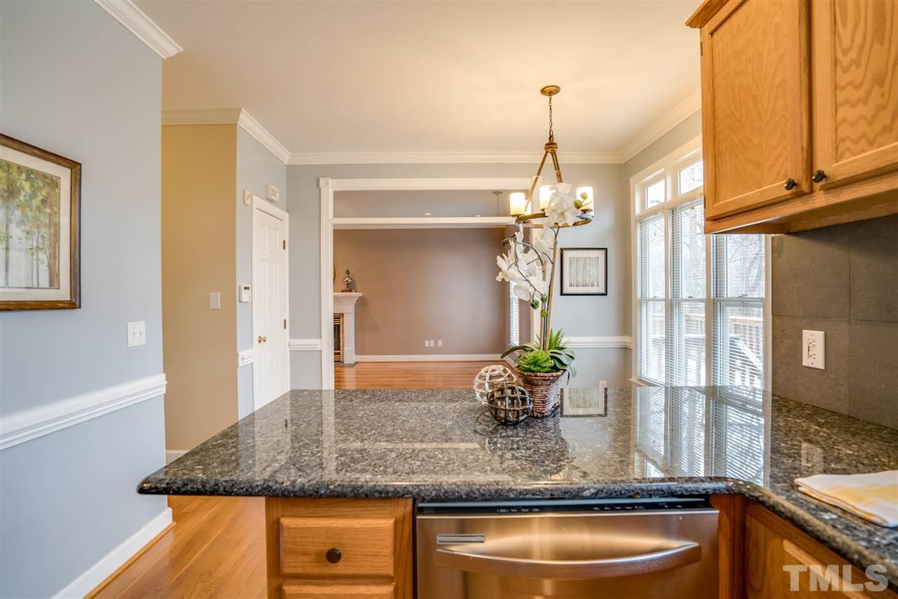 9905 Rimwood Court Raleigh, NC 27613 - Photo 13 of 24 a kitchen with kitchen island a counter top space and a chandelier