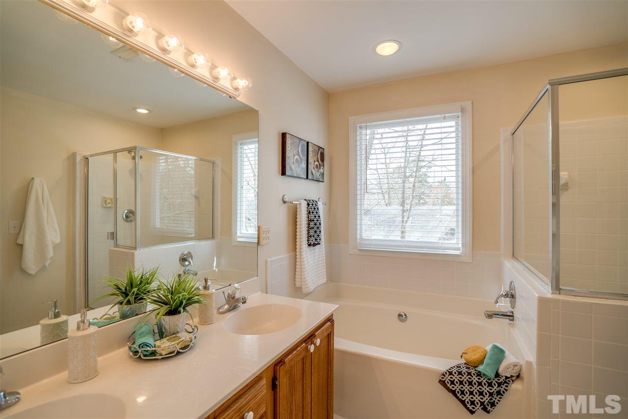 9905 Rimwood Court Raleigh, NC 27613 - Photo 16 of 24 a bathroom with a bathtub sink and mirror