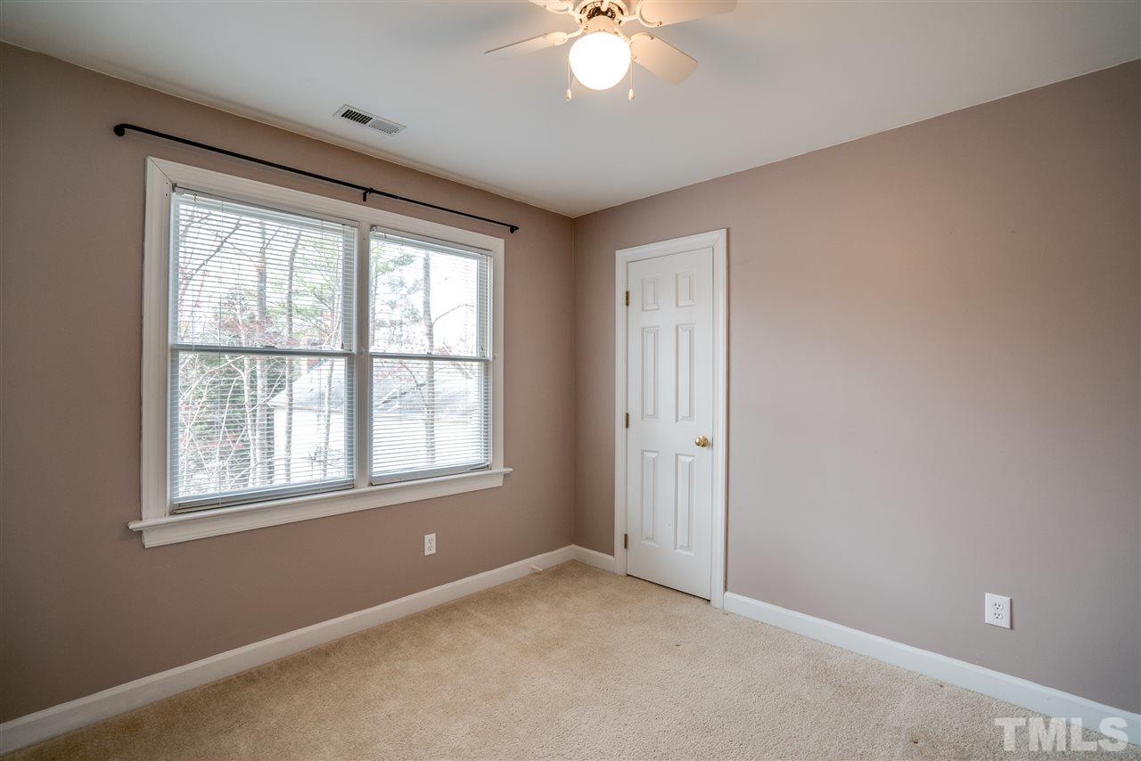 9905 Rimwood Court Raleigh, NC 27613 - Photo 18 of 24 an empty room with chandelier fan and windows