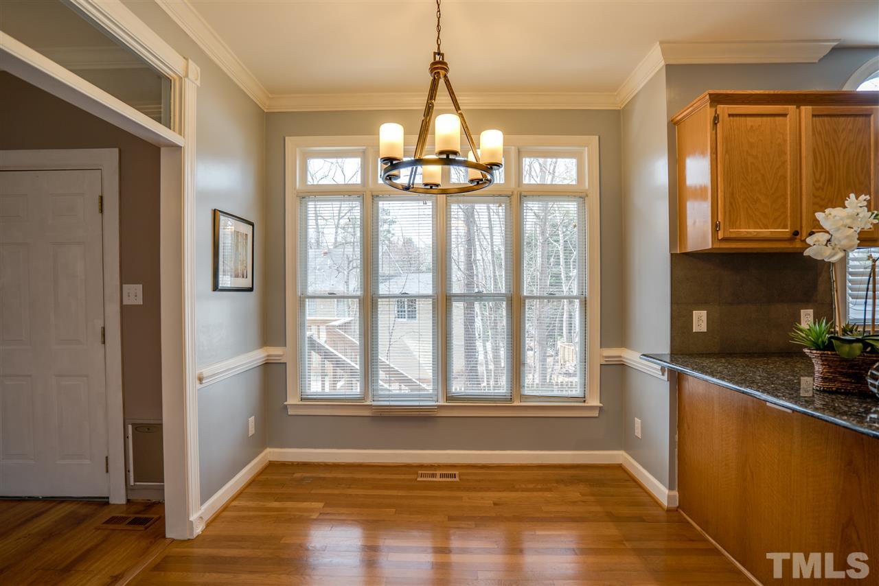 9905 Rimwood Court Raleigh, NC 27613 - Photo 9 of 24 a view of an empty room with a window and wooden floor
