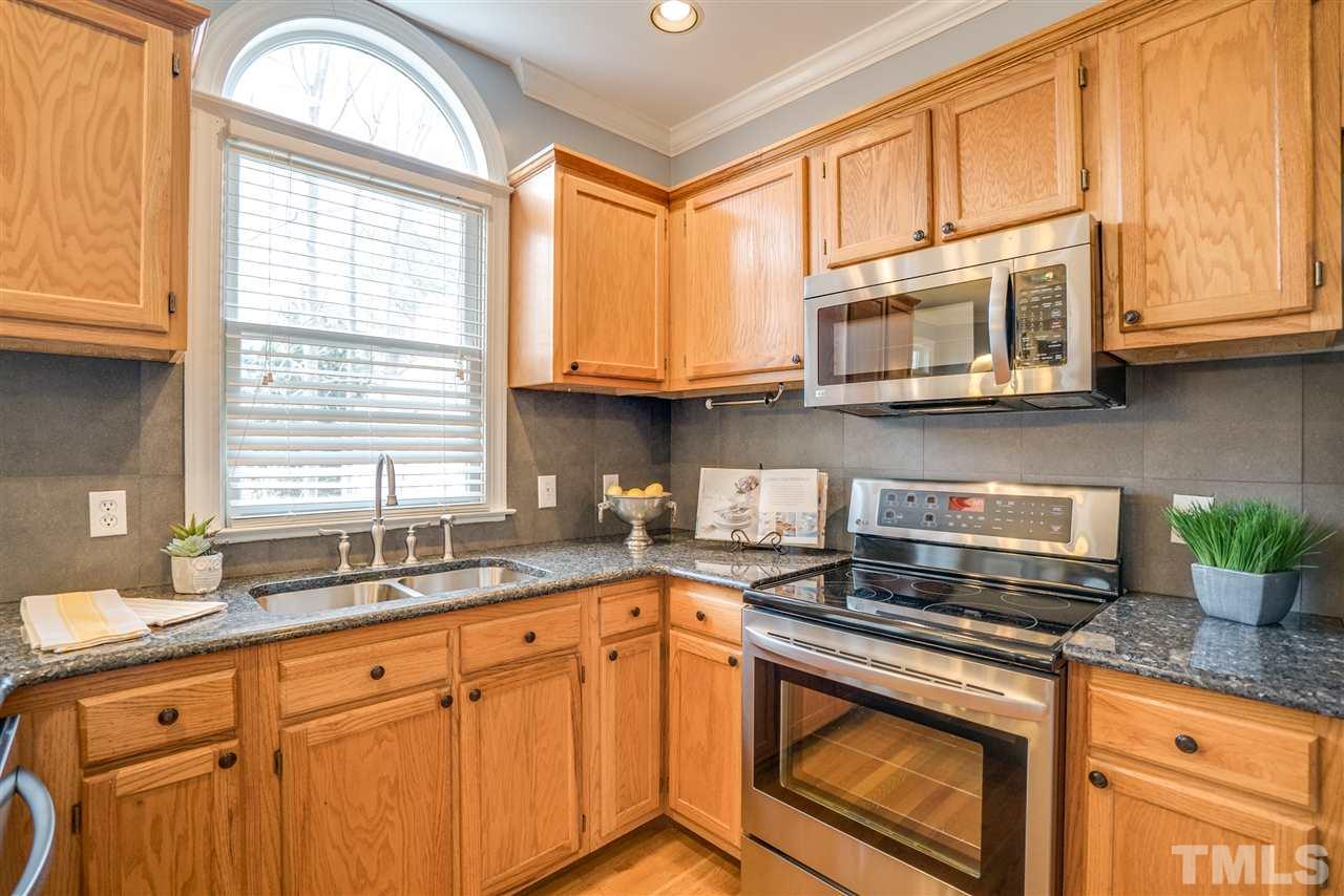 9905 Rimwood Court Raleigh, NC 27613 - Photo 10 of 24 a kitchen with stainless steel appliances granite countertop a sink a stove and a microwave