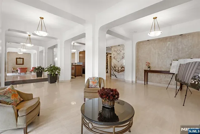a living room with a potted plant and open kitchen view