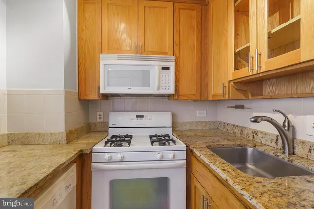 a kitchen with stainless steel appliances granite countertop a sink stove and cabinets