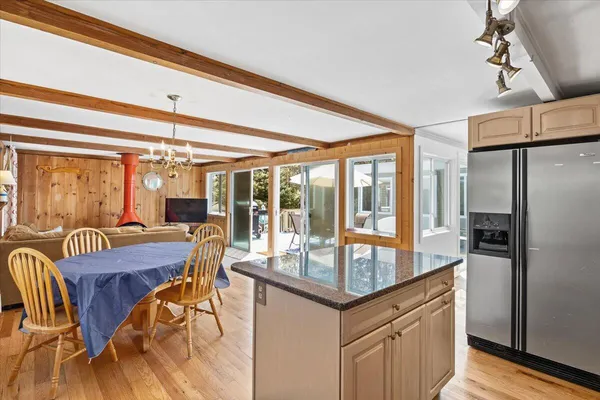 a dining hall with stainless steel appliances granite countertop a dining table and chairs