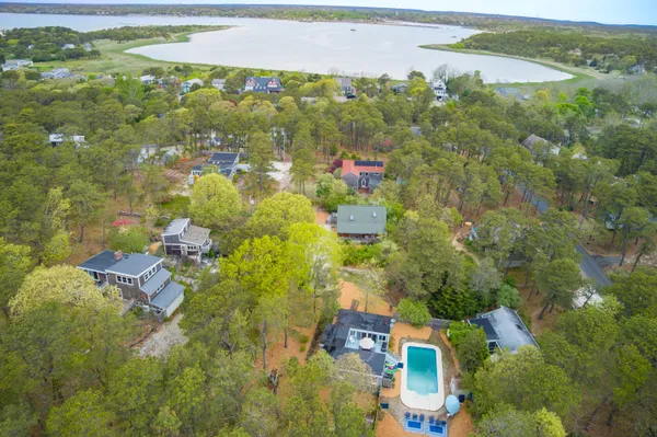 an aerial view of residential houses with outdoor space and trees
