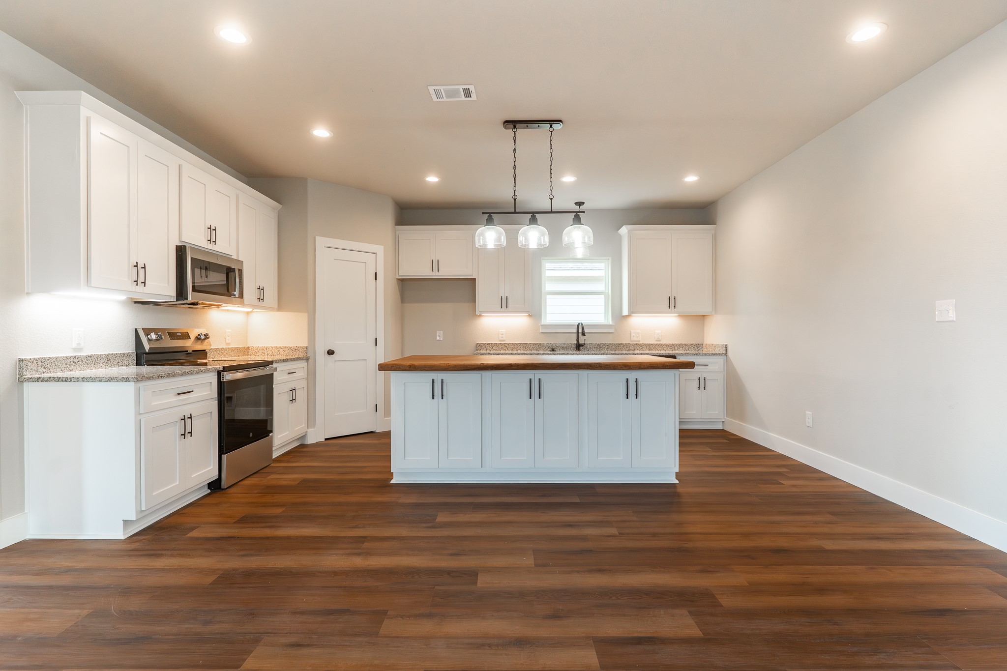 305 String Prairie Way Smithville, TX 78957 - Photo 5 of 26 a large kitchen with stainless steel appliances granite countertop a stove a sink dishwasher and a oven with white cabinets