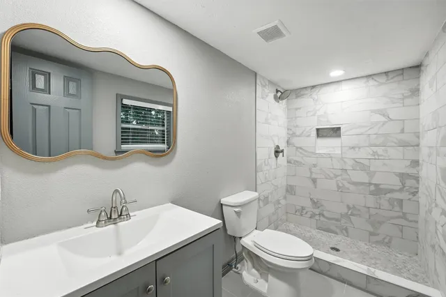 a bathroom with a sink a toilet and shower