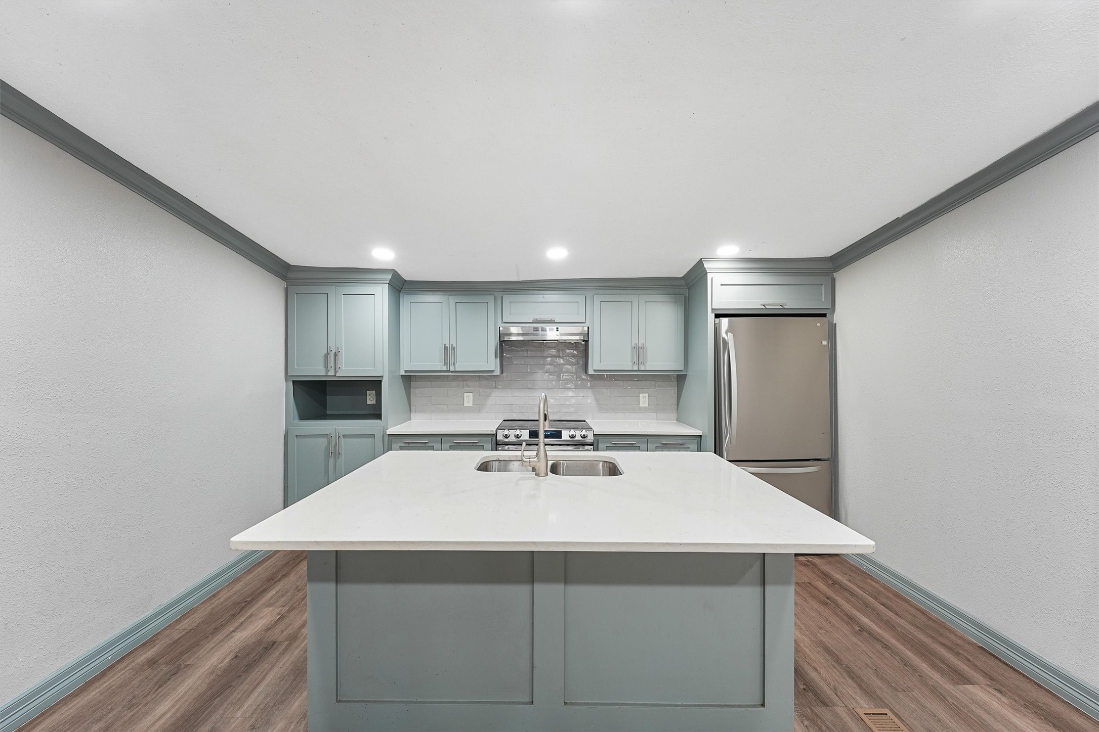 110 Robin Street Shepherd, TX 77371 - Photo 6 of 23 a kitchen with a sink a refrigerator and white cabinets