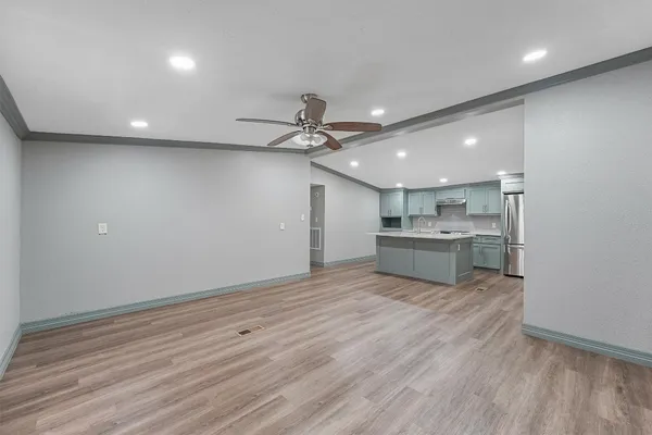 a view of a kitchen with a sink and wooden floor