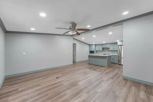 a view of a kitchen with a sink and wooden floor