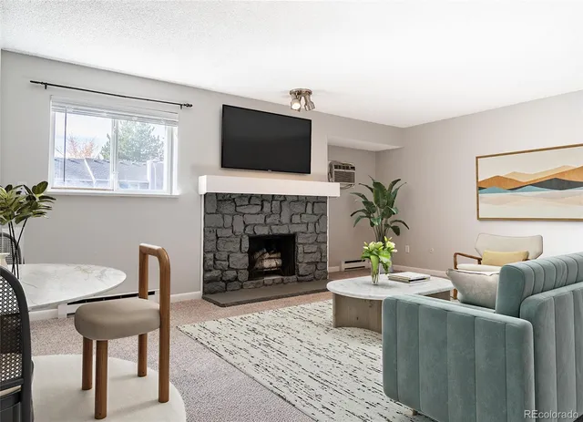 a living room with furniture a flat screen tv and a fireplace