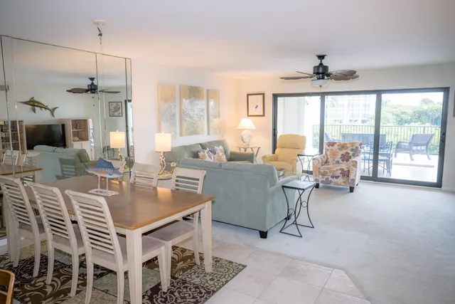 a dining room with furniture a chandelier and window