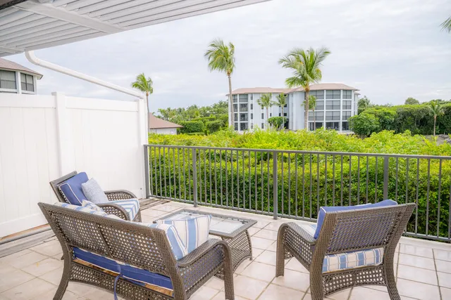 a view of a chair and tables in the back yard of the house