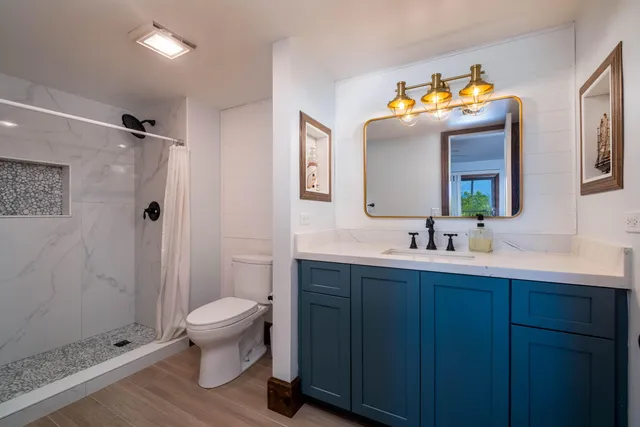 a bathroom with a sink vanity mirror and toilet
