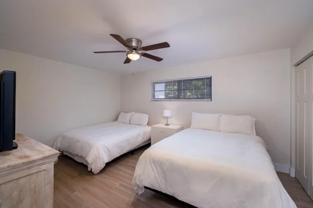 a bedroom with two beds and painting on the wall