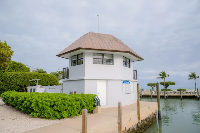 a front view of a house with a yard and potted plants