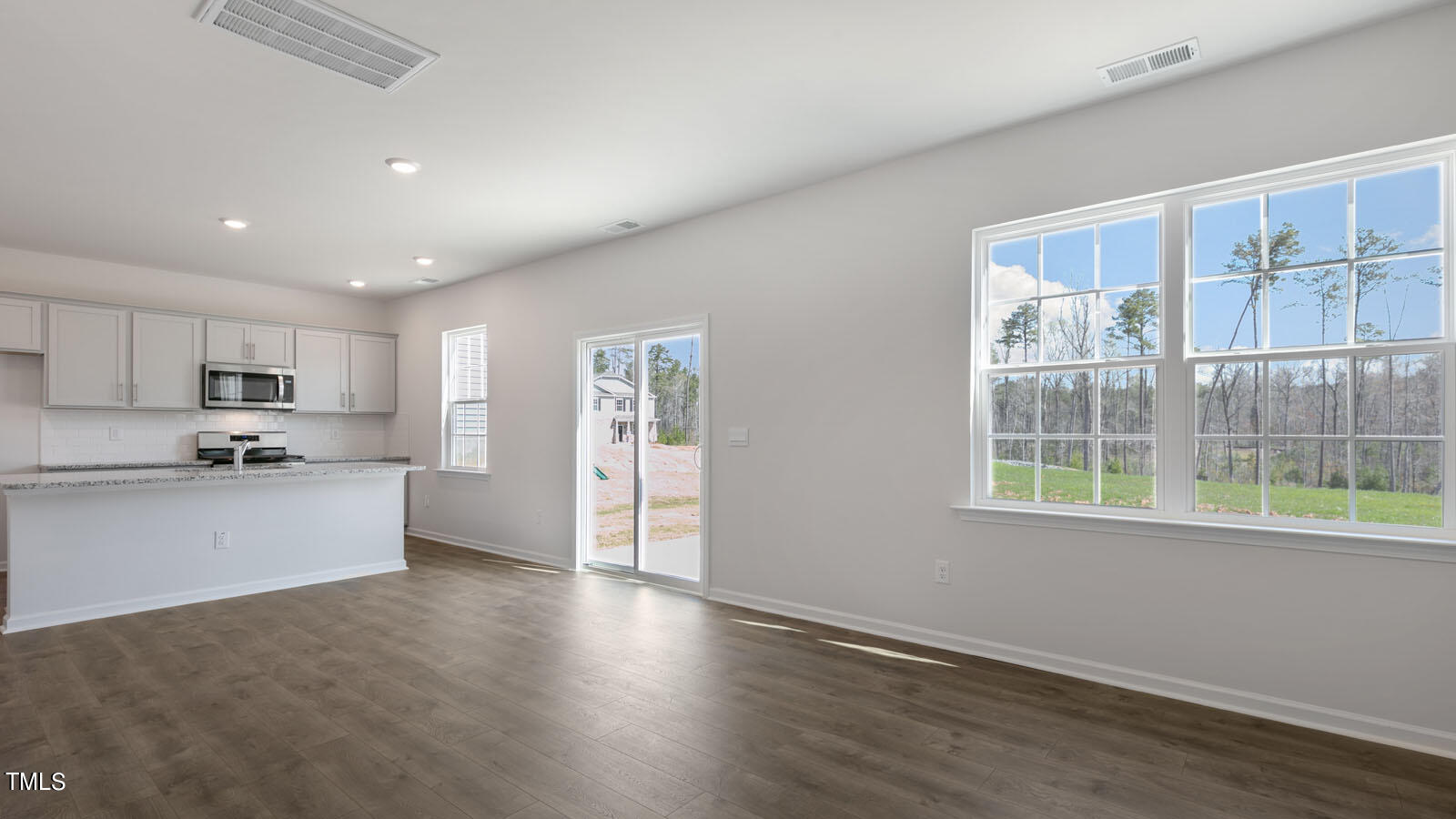 361 Ashley Run Sanford, NC 27330 - Photo 14 of 46 a large kitchen with stainless steel appliances granite countertop a large window a oven and white cabinets with wooden floor