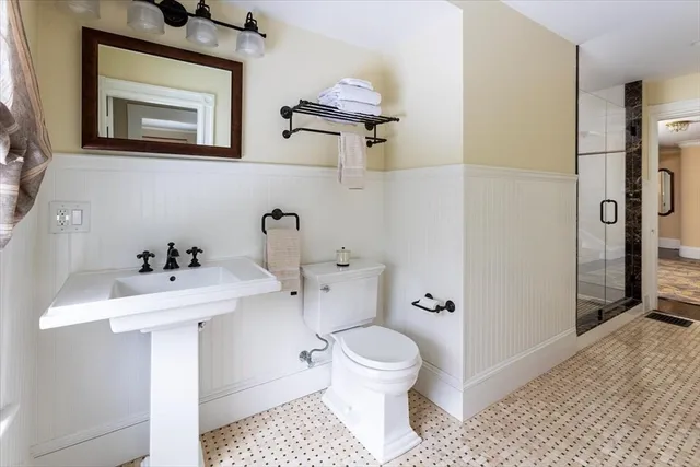 a bathroom with a sink a toilet and shower