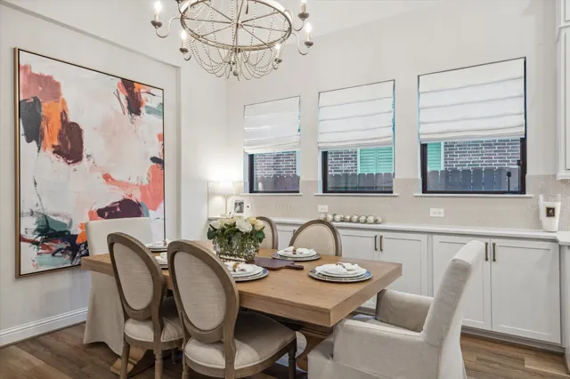 a dining room with furniture a chandelier and wooden floor