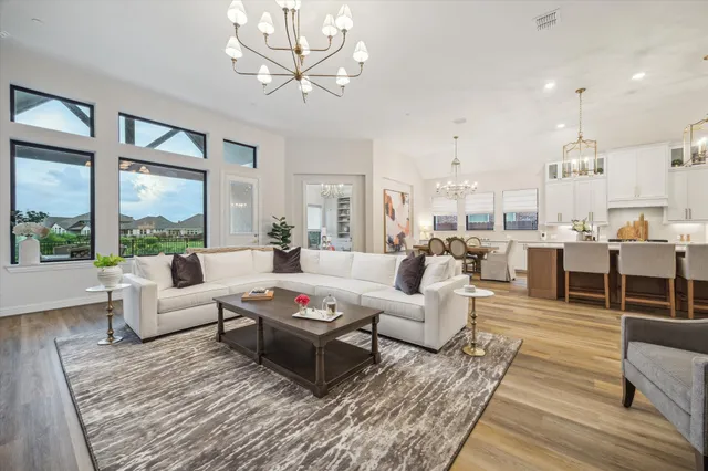 a living room with furniture wooden floor and a large window