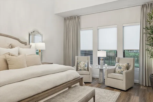 a bedroom with a large bed and a flat tv screen on dresser