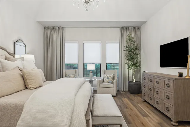 a bedroom with a large bed and a chandelier